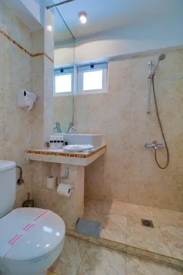 a bathroom with a toilet and a sink and a shower at Palace Hotel Glyfada in Athens