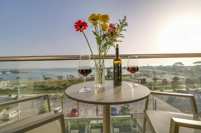 a table with two glasses of wine and flowers at Palace Hotel Glyfada in Athens