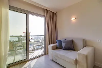 a living room with a couch and a large window at Palace Hotel Glyfada in Athens