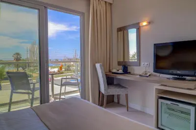 a hotel room with a bed and a desk with a television at Palace Hotel Glyfada in Athens