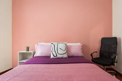 a pink bedroom with a bed and a chair at Varkiza Escape Residence in Vari