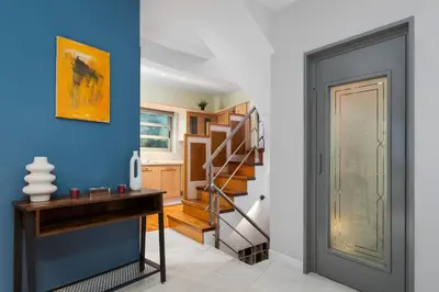a hallway with a staircase and a blue wall at Varkiza Escape Residence in Vari