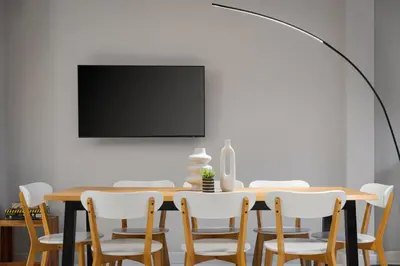 a dining room with a table and chairs and a flat screen tv at Varkiza Escape Residence in Vari