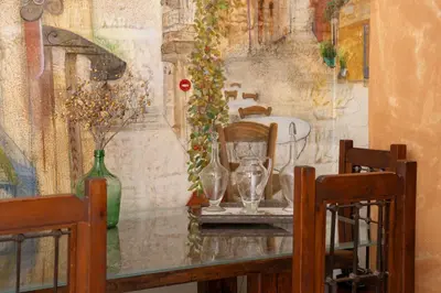 a table with vases on it with a painting on the wall at Vintage Place Near ATH Airport in Markopoulo