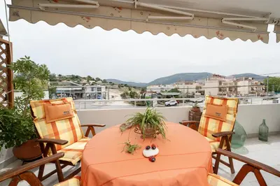 a table and chairs on a balcony with a view at Vintage Place Near ATH Airport in Markopoulo