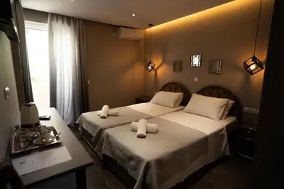 two beds in a hotel room with towels on them at Parthenis Riviera Hotel in Athens