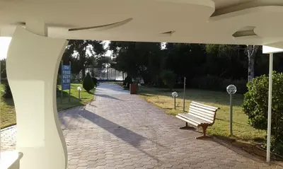 a park bench sitting on a brick walk way at Parthenis Riviera Hotel in Athens