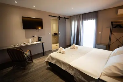a hotel room with a large bed with towels on it at Parthenis Riviera Hotel in Athens