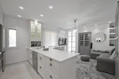 a large white kitchen with a couch and a table at Belva Blue Glyfada Modern 2BR Walk to Ctr & Beach in Athens