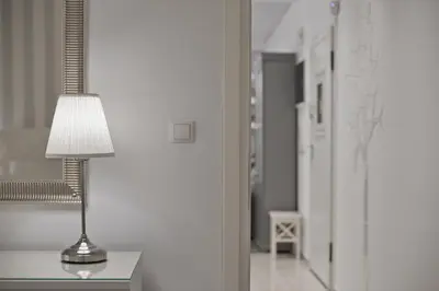 a lamp sitting on a table next to a hallway at Belva Blue Glyfada Modern 2BR Walk to Ctr & Beach in Athens