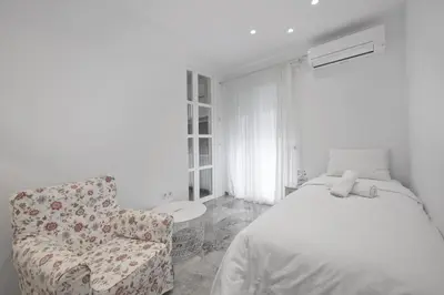 a bedroom with a bed and a chair at Belva Blue Glyfada Modern 2BR Walk to Ctr & Beach in Athens