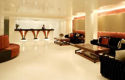a man sitting at a piano in a living room at Piraeus Theoxenia Hotel in Piraeus
