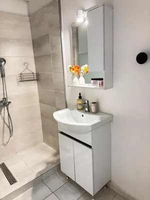 a white bathroom with a sink and a shower at SIS Urban Apartments in Athens