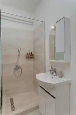 a white bathroom with a shower and a sink at SIS Urban Apartments in Athens