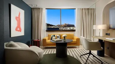 a living room with a yellow couch and a table at Athenaeum Intercontinental by IHG in Athens