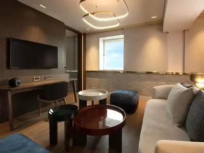 a living room with a couch and a flat screen tv at Sofitel Athens Airport in Athens