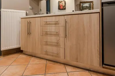a kitchen with wooden cabinets and a tile floor at The heart of Plaka in Athens