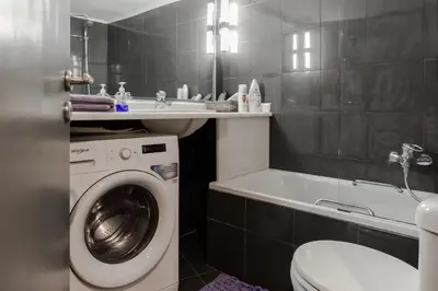 a bathroom with a washing machine and a bath tub at The heart of Plaka in Athens