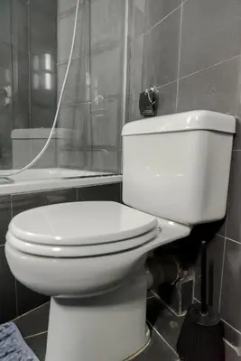 a bathroom with a white toilet and a bath tub at The heart of Plaka in Athens