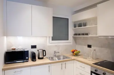 a kitchen with white cabinets and a sink and a microwave at La Residence Athens in Athens