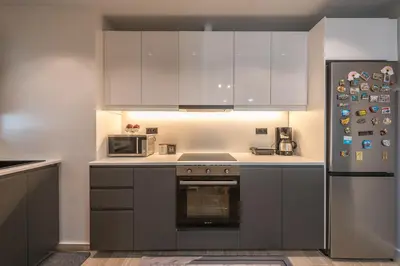 a kitchen with stainless steel appliances and white cabinets at Comfy and modern apartment in Athens