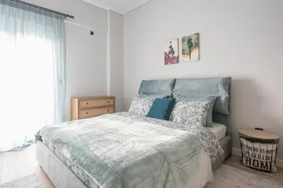 a bedroom with a large bed and a window at Comfy and modern apartment in Athens