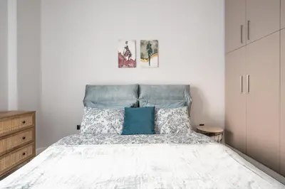 a bedroom with a bed with a blue headboard at Comfy and modern apartment in Athens