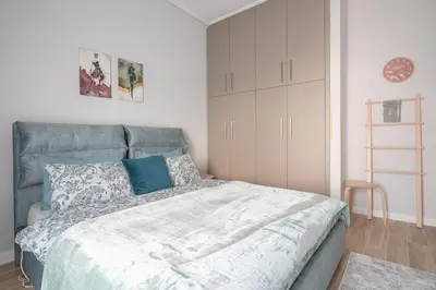 a bedroom with a bed with blue and white sheets at Comfy and modern apartment in Athens