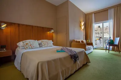 a hotel room with a large bed and a chair at Philippos Hotel in Athens