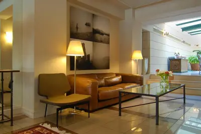 a living room with a leather couch and a glass table at Philippos Hotel in Athens