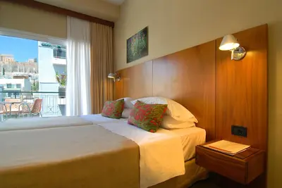 a hotel room with a bed and a balcony at Philippos Hotel in Athens