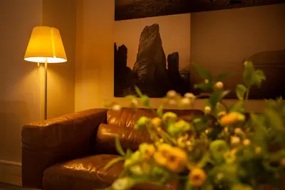 a living room with a brown couch and a lamp at Philippos Hotel in Athens