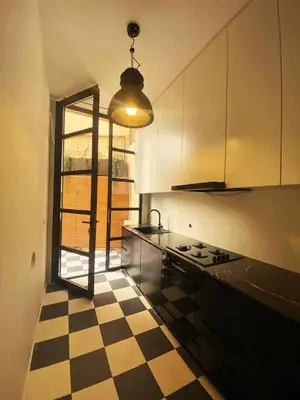 a kitchen with a black and white checkered floor at Herodion Hotel in Athens