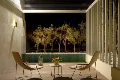 a patio with two chairs and a table with a vase of flowers at Herodion Hotel in Athens