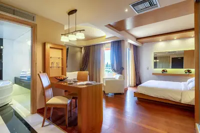 a hotel room with a bed and a desk and a bedroom at Oasis Hotel Apartments in Athens