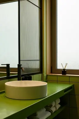 a bathroom with a white sink and two windows at DWELL - Elegant City Stay in Athens