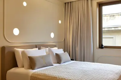 a bedroom with a bed with white pillows and a window at DWELL - Elegant City Stay in Athens