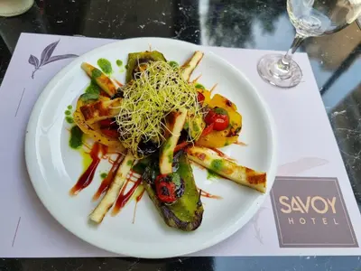a white plate with food on a table at Savoy Hotel in Piraeus