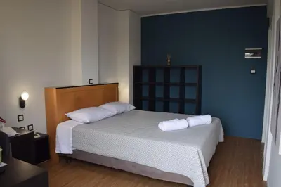 a bedroom with a bed with two pillows on it at Savoy Hotel in Piraeus