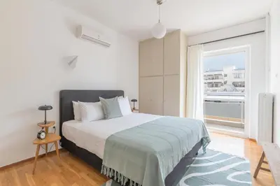 a bedroom with a bed and a large window at Outstanding 2BR Apartment in Cholargos by UPSTREET in Athens