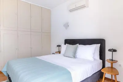 a white bedroom with a large bed with white cabinets at Outstanding 2BR Apartment in Cholargos by UPSTREET in Athens