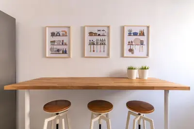 a table and stools in a room with pictures on the wall at Outstanding 2BR Apartment in Cholargos by UPSTREET in Athens