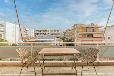 a wooden table and chairs on a balcony with buildings at Outstanding 2BR Apartment in Cholargos by UPSTREET in Athens