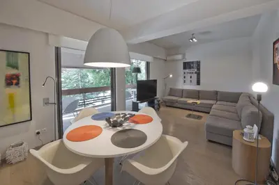 a living room with a table and a couch at Sea Breeze Spacious Apt near Vouliagmeni Beach in Athens