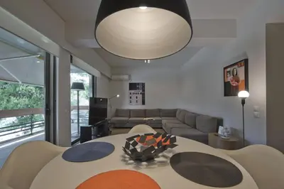 a living room with a table and a couch at Sea Breeze Spacious Apt near Vouliagmeni Beach in Athens