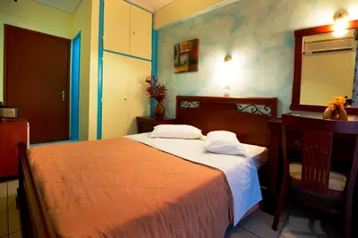 a bedroom with a bed and a desk and a mirror at Pergamos Hotel in Athens