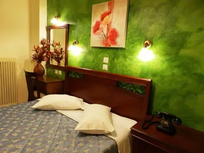 a bedroom with a bed and a green wall at Pergamos Hotel in Athens