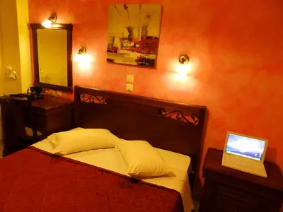 a bedroom with a bed with a laptop on it at Pergamos Hotel in Athens