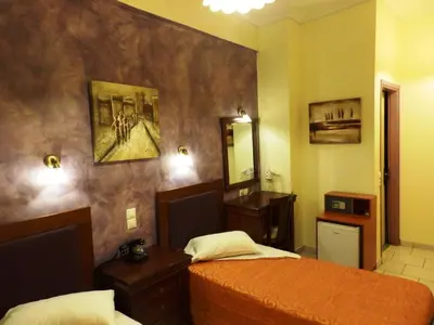a hotel room with two beds and a mirror at Pergamos Hotel in Athens