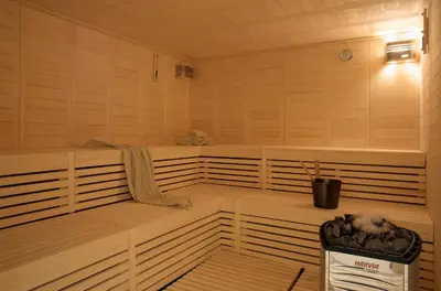 a sauna with two benches and a trash can in it at Zeus Dolce by Wyndham Athens in Vravrona